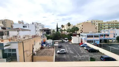 a city street with cars parked in a parking lot at City Center: Your Urban Retreat- 100m to the beach in Larnaka