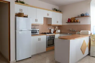 a kitchen with white cabinets and a white refrigerator at Apartment Kamilla- Kaparis in Paralimni