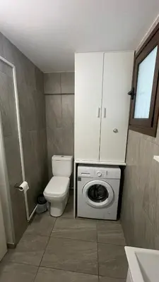 a bathroom with a toilet and a washing machine at Apartment Kamilla- Kaparis in Paralimni