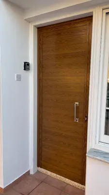 a wooden door in a building with a window at Apartment Kamilla- Kaparis in Paralimni