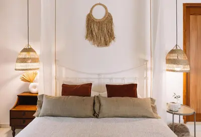 a bedroom with a large bed and two pendant lights at Anerada Cottages in Apsiou