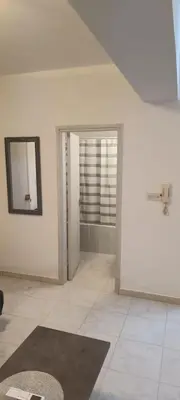 a white room with a mirror and a rug at Sea-side City centre Studio in Larnaka