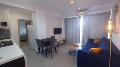 a living room with a blue couch and a table at Coco De Mer 408 in Limassol