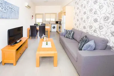 a living room with a couch and a table at Bowker Apartment in Protaras