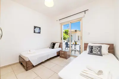 a bedroom with two beds and a balcony at Alex Villa Kapparis in Protaras