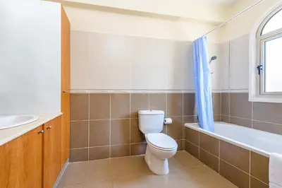 a bathroom with a toilet and a tub and a sink at Alex Villa Kapparis in Protaras