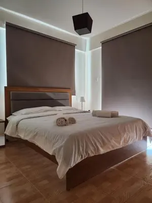a bedroom with a large bed with two towels on it at Maestro III Apartment in Larnaka