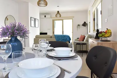 a living room with a table with plates and wine glasses at Palm Village Escape in Protaras