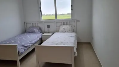 a small bedroom with two beds and two windows at The Olive Grove Escape, Eleonas Apts in Sotira