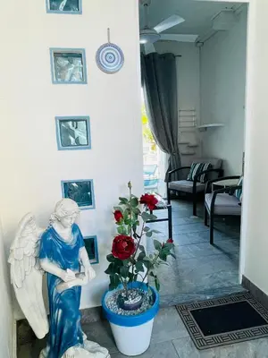 a statue of an angel sitting next to a plant at House of Hera in Livadhia