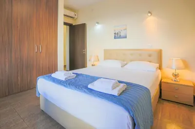 a bedroom with a large white bed with towels on it at Seafront Protaras Villas in Protaras