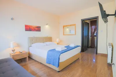 a bedroom with a bed with a blue blanket at Seafront Protaras Villas in Protaras