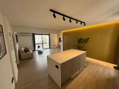 a living room with a table and a yellow wall at Modern 2bed in the centre in Nicosia