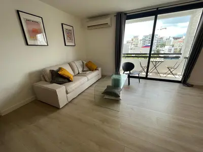 a living room with a couch and a large window at Modern 2bed in the centre in Nicosia