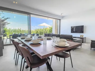 a dining room with a large wooden table and chairs at Azure Vista Collection in Protaras