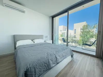 a bedroom with a large bed and a large window at Azure Vista Collection in Protaras