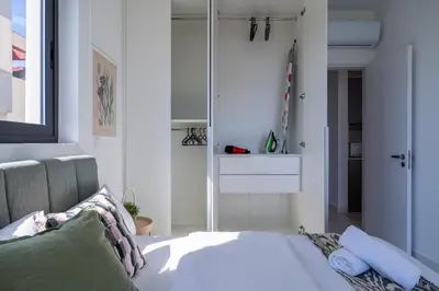 a bedroom with a bed and a mirror at Ivory 1-BR Apartment in Aradipou in Aradhippou