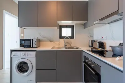 a kitchen with a washing machine and a sink at Ivory 1-BR Apartment in Aradipou in Aradhippou