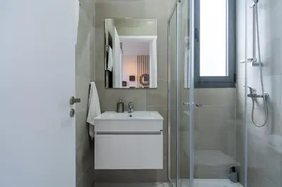 a bathroom with a white sink and a shower at Ivory 1-BR Apartment in Aradipou in Aradhippou