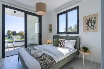 a bedroom with a king sized bed with windows at Ivory 1-BR Apartment in Aradipou in Aradhippou