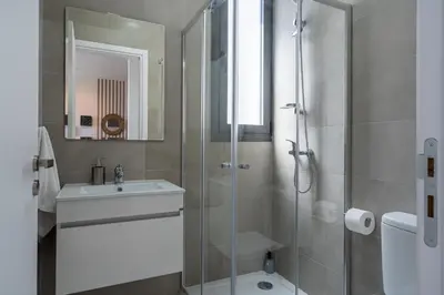 a bathroom with a glass shower and a sink at Ivory 1-BR Apartment in Aradipou in Aradhippou