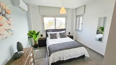 a bedroom with a bed and a large window at Sealife Citycenter Residences in Larnaka