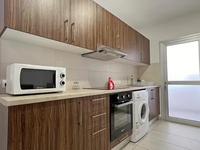 a kitchen with a microwave oven and a stove at Albert's Apartment Center 202B in Larnaka