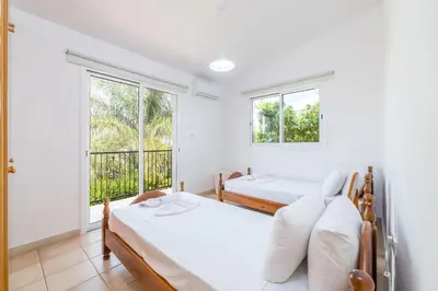 two beds in a room with two windows at Thekla Oasis Villa in Ayia Napa