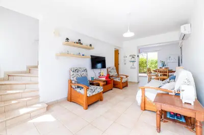 a living room with a couch and chairs and a staircase at Thekla Oasis Villa in Ayia Napa