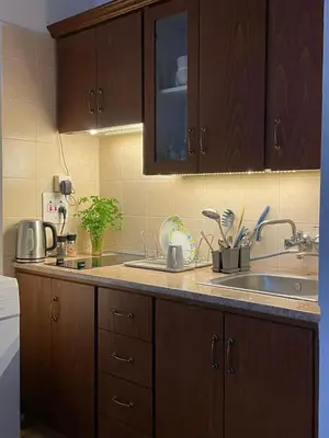 a kitchen with wooden cabinets and a sink at STAY Dreamy Seaside Apartment in Larnaka