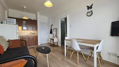 a kitchen and a living room with a table and chairs at STAY Dreamy Seaside Apartment in Larnaka