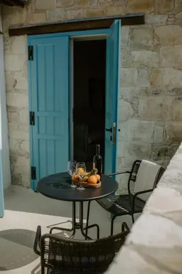a table with wine glasses and fruit on a patio at Smaragda's Guest Rooms in Limassol