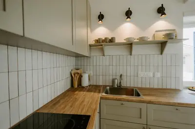 a kitchen with white tiled walls and a sink at Smaragda's Guest Rooms in Limassol