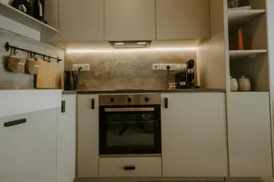 a kitchen with white cabinets and an oven at Smaragda's Guest Rooms in Limassol