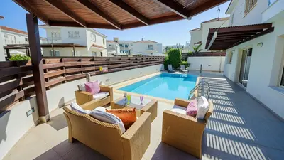 a balcony with two chairs and a swimming pool at Pernera Holiday Villa 015 in Protaras