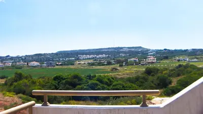 a bench on a balcony with a view of a field at Pernera Holiday Villa 012 in Protaras