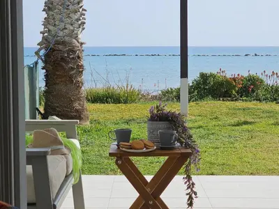 a table with two cups and some bread on it at Ammos Beachfront Villa Paradise in Larnaka