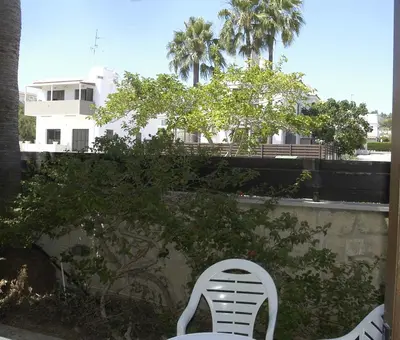a white chair sitting on a balcony with a building at Summer Breeze in Paralimni