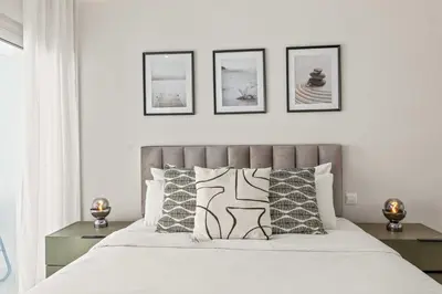 a bedroom with a bed with four pictures on the wall at Phaedrus Living: Limassol Seaside Residences 02 in Limassol