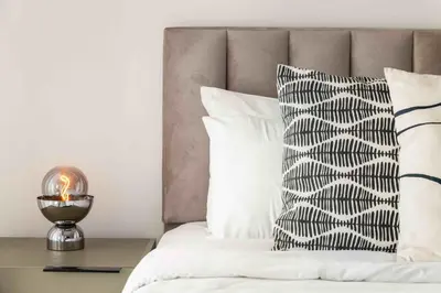 a bed with a black and white pillow and a candle at Phaedrus Living: Limassol Seaside Residences 02 in Limassol