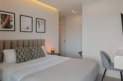 a bedroom with a large bed and a chair at Phaedrus Living: Limassol Seaside Residences 03 in Limassol