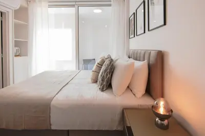 a bedroom with a bed with pillows and a table at Phaedrus Living: Limassol Seaside Residences 03 in Limassol