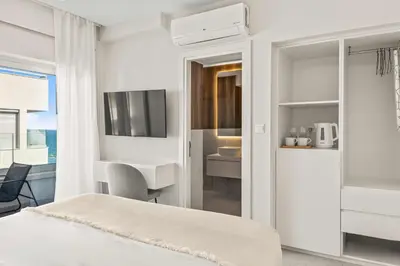 a bedroom with a bed and a desk and a sink at Phaedrus Living Coastal Seaside Residences 04 in Limassol