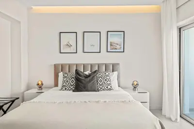 a white bedroom with a large bed with pillows at Phaedrus Living Coastal Seaside Residences 04 in Limassol