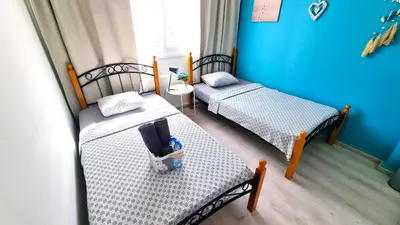 two twin beds in a room with blue walls at 2Br Apt Coastal Comfort with Internet Access in Larnaka
