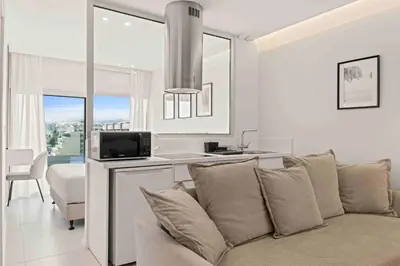 a living room with a couch and a kitchen at Phaedrus Living Limassol Seaside Residences 06 in Limassol