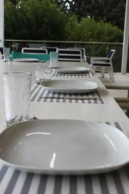 a table with two white plates on a striped table cloth at The Olive Tree in Protaras