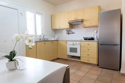 a kitchen with wooden cabinets and a stainless steel refrigerator at Hubstay Hillside Residence with Private Jacuzzi in Platres