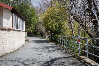 a road next to a fence next to a building at Hubstay Hillside Residence with Private Jacuzzi in Platres