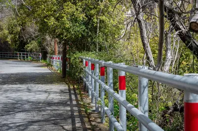 a fence with red and white poles next to a road at Hubstay Hillside Residence with Private Jacuzzi in Platres